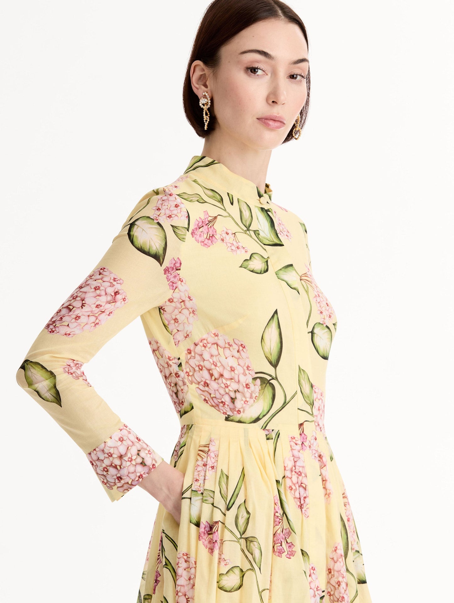 Long-sleeve, yellow cotton poplin midi dress. Porcelain flower print. Pleated silhouette. Concealed button front. Softly structured collar. Side View.