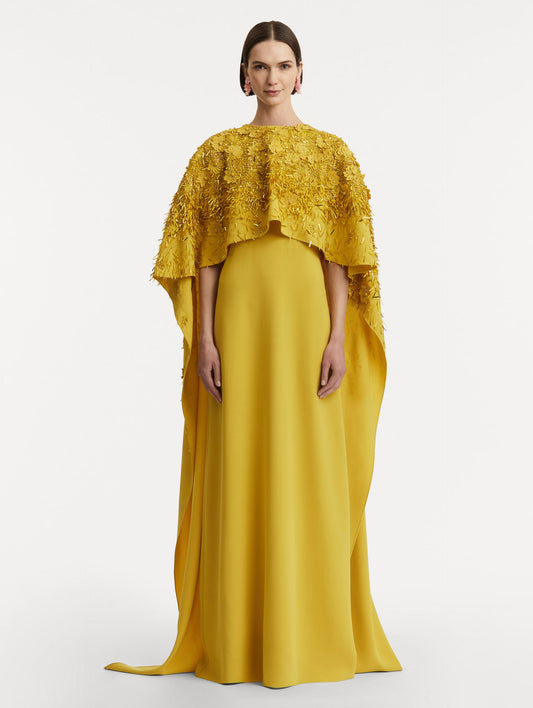 Full body front view of model wearing a yellow caftan with gold sequin and peony embroidery.