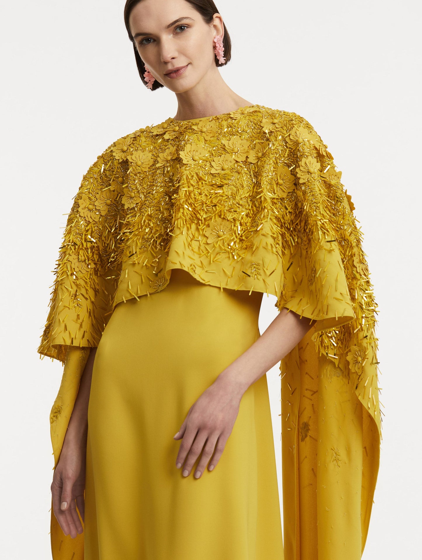 Zoomed in photo of model wearing a yellow caftan with gold sequin and peony embroidery.