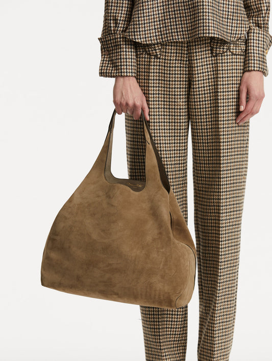 Photo of model holding The Topaz in a suede taupe front view.
