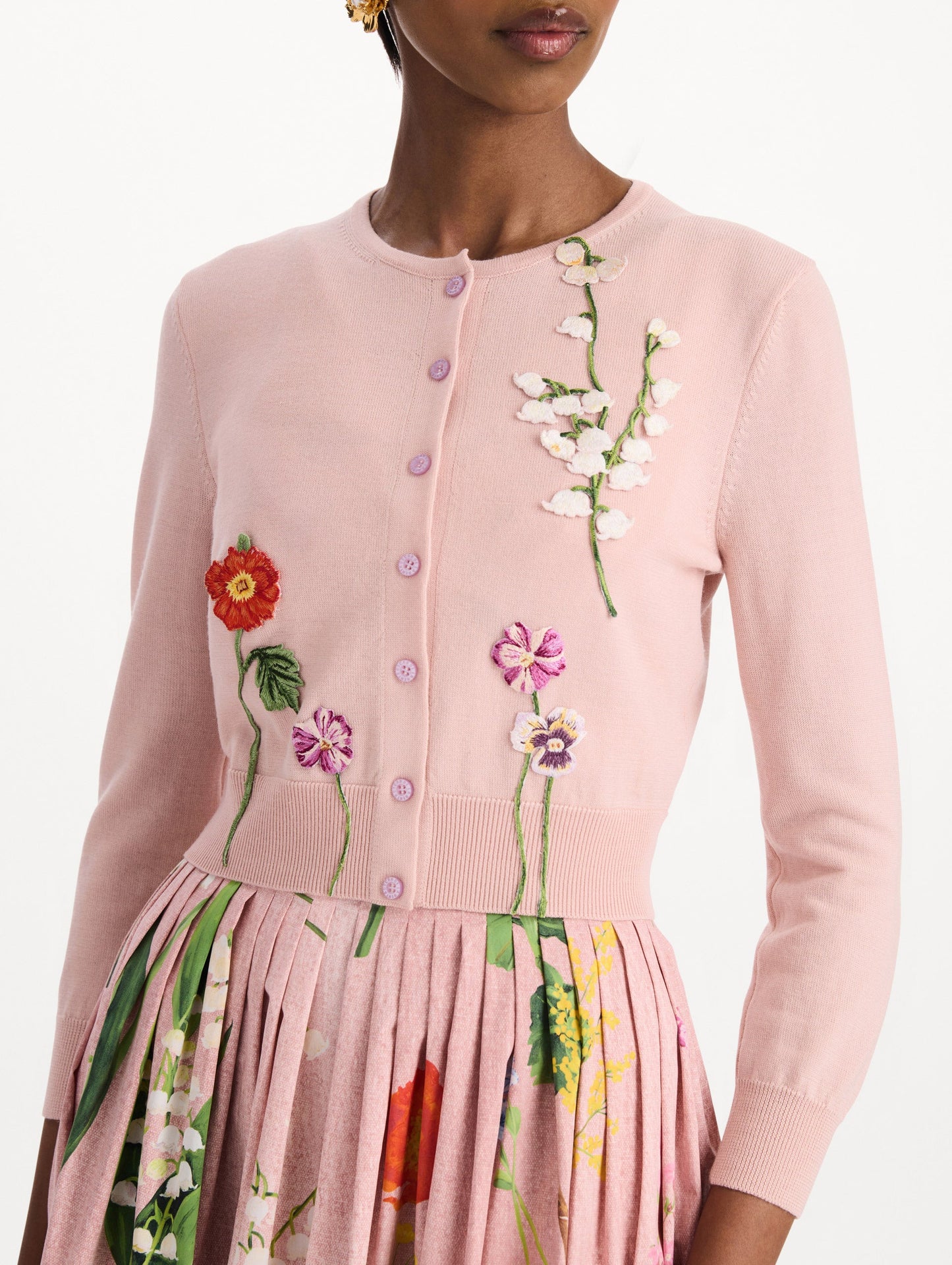 The model is wearing the mixed botanical threadwork cardigan in the color blush with floral detailing. Zoom view.