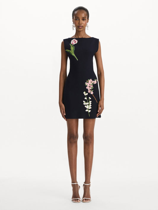 The model is wearing the mixed botanical embroidered dress with an A-line silhouette in a navy wool blend. Front view.