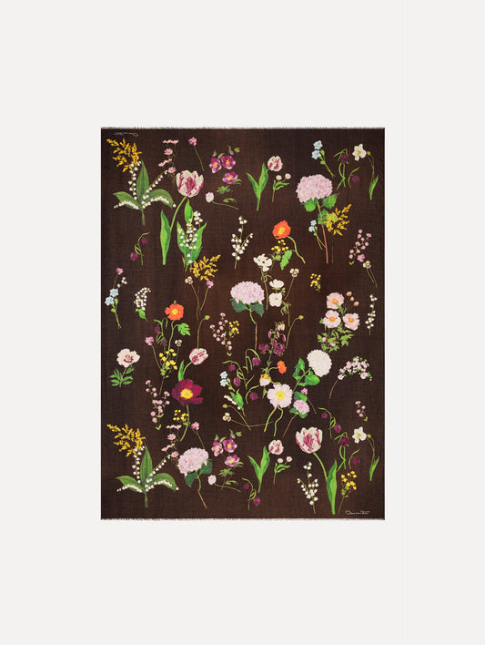 The model is wearing the mixed botanical scarf with an all-over floral print in the color brown. Full view.