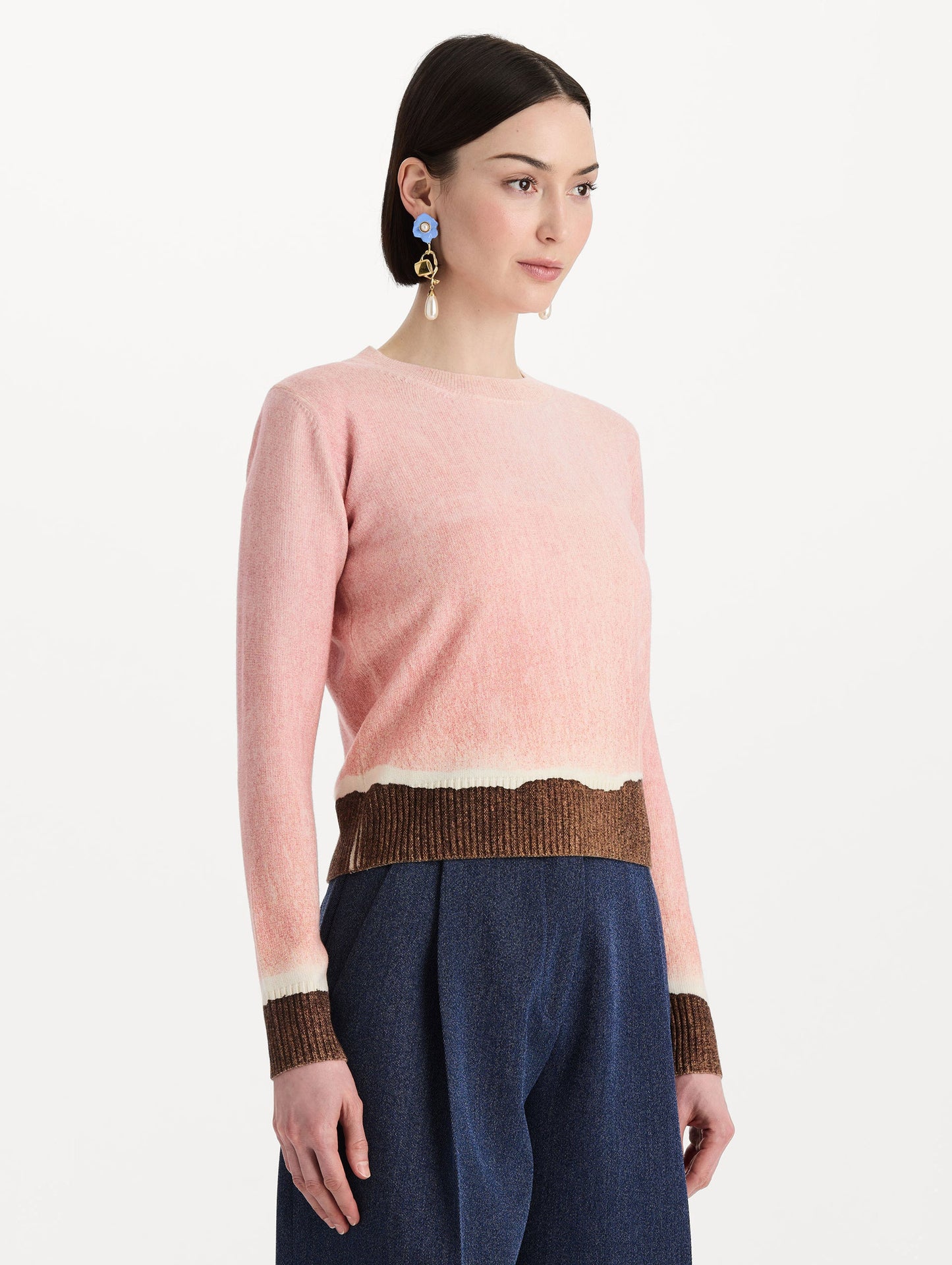 The model is wearing the ombré crewneck pullover with a painterly print in a pink and brown palette. Side view.