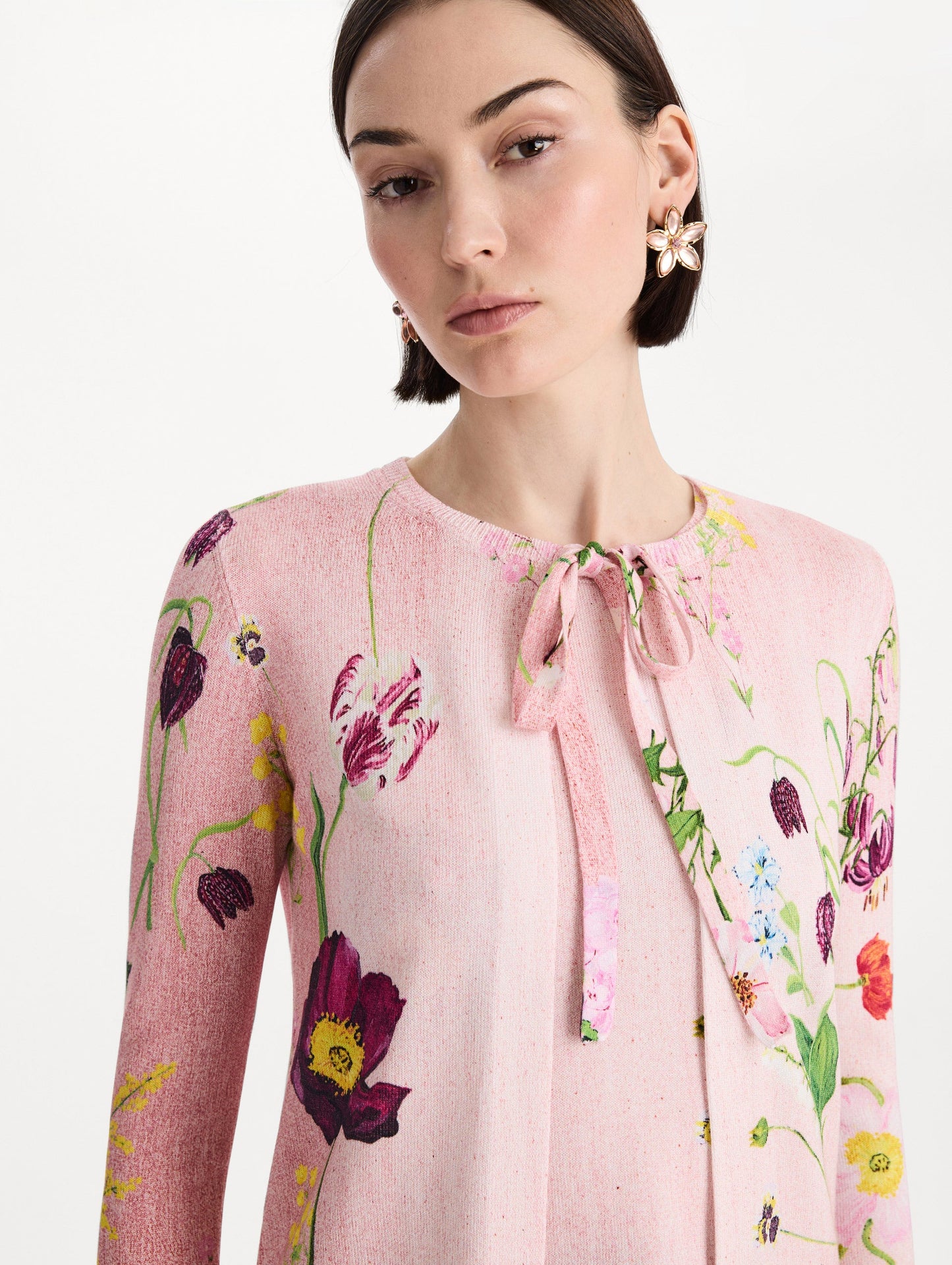 The model is wearing the mixed botanical tie-neck cardigan with an all-over floral print in blush multi. Zoom view.