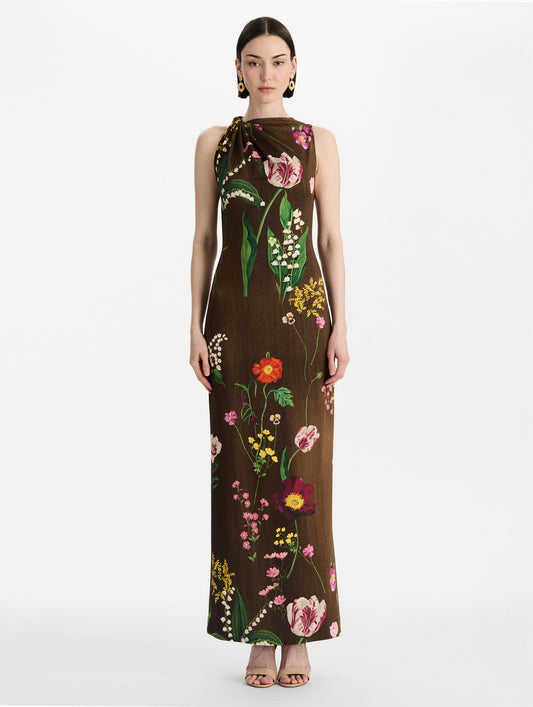 The model is wearing the mixed botanical Milano jersey dress with a sleeveless silhouette in a brown multi palette. Front view.