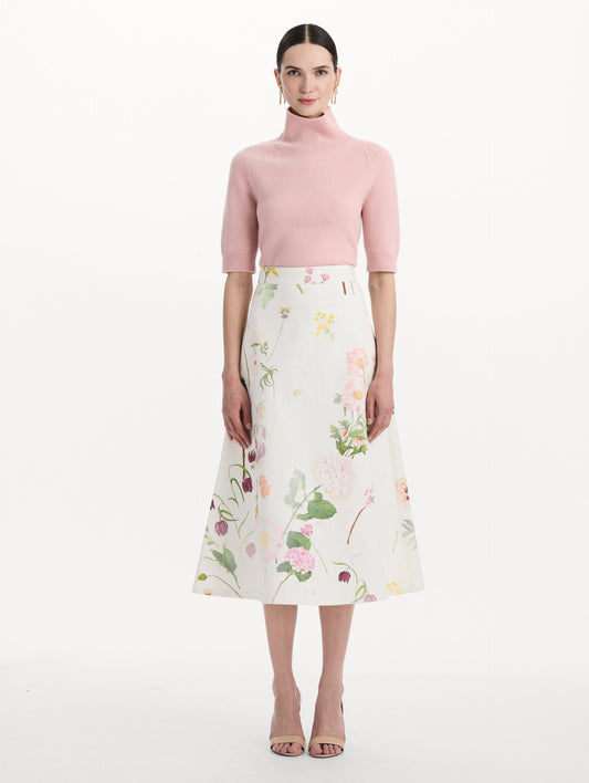 The model is wearing the faded mixed botanical denim midi skirt in the color white multi. Front view.