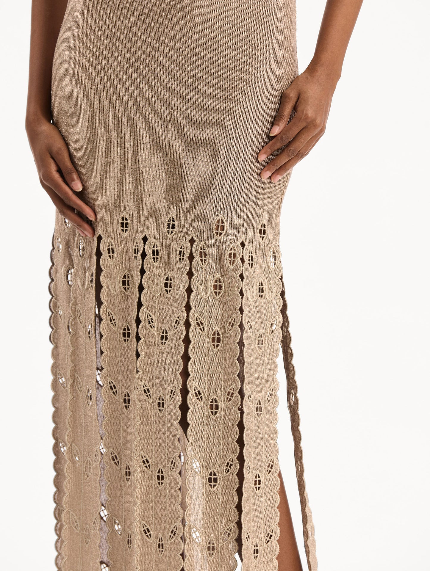 The model is wearing the Pineapple Fringe Metallic Jersey Dress. Featuring shimmering metallic jersey fabrication, a body-skimming silhouette, and pineapple-inspired fringe along the hem. Detail View.