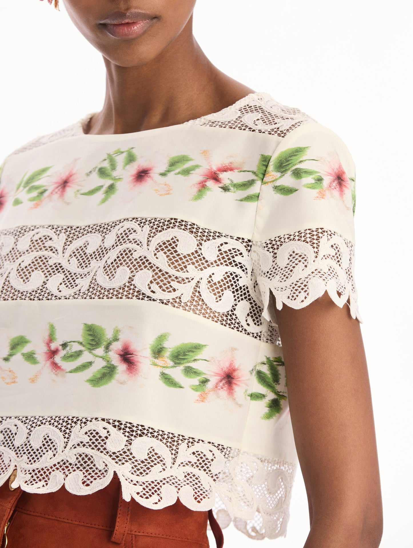 The model is wearing the chiné hibiscus striped cotton poplin blouse with guipure lace panels and a striped floral pattern in the color ivory. Zoom view.