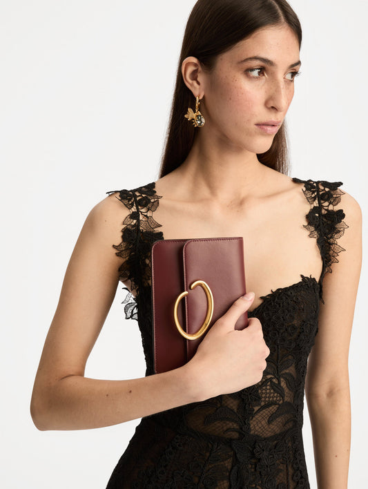 Maroon O Pochette with gold hardware and abstract O Clasp. Front View.