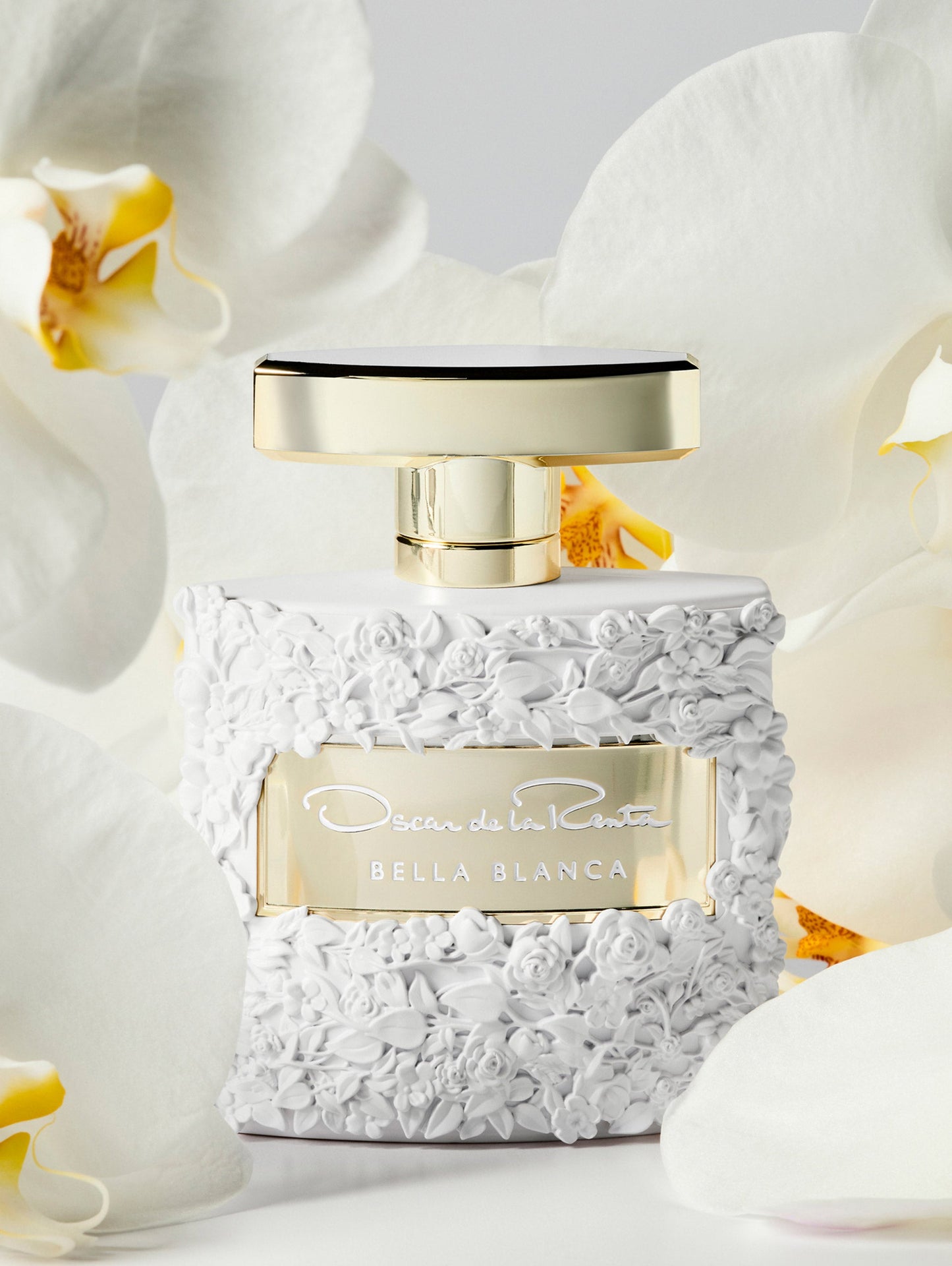 Oscar White Rose Texture Bella Blanca Perfume Bottle Surrounded by White Orchids Front View