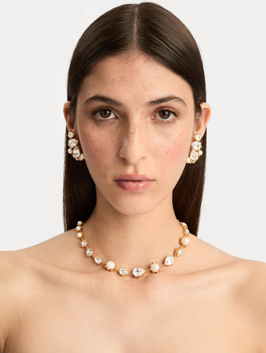 Gold Faceted Crystal Necklace featuring alternating white pearls and clear crystal settings in a graduated design. Front View.