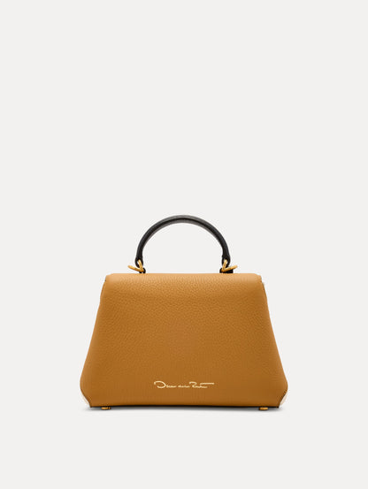 The Mini Poppy Handbag in Honey with Black Top Handle. Adorned with Signature Oscar de la Renta Logo in the Bottom Center. Back View