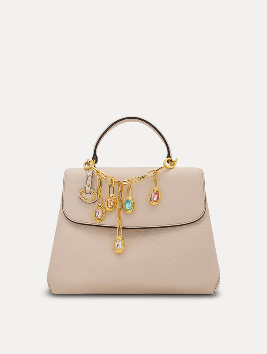 Pink, Orange, and Blue Crystals O Bag Charm in Gold styled with an ivory mini top handle handbag. Front View