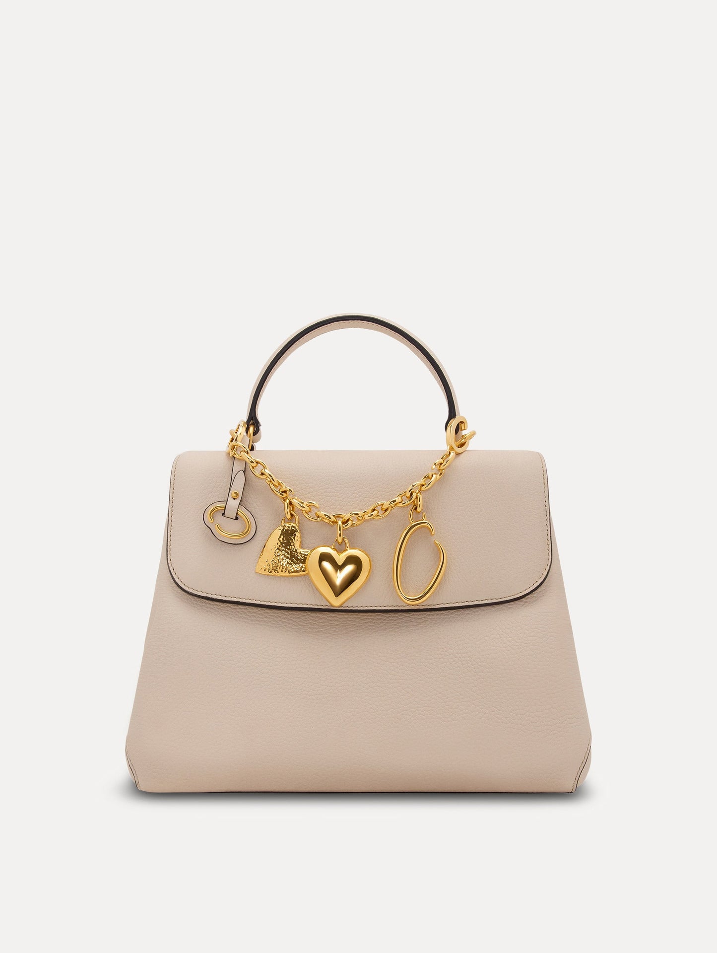 Heart & O Bag Charm in Gold styled with an ivory mini top handle handbag. Front View