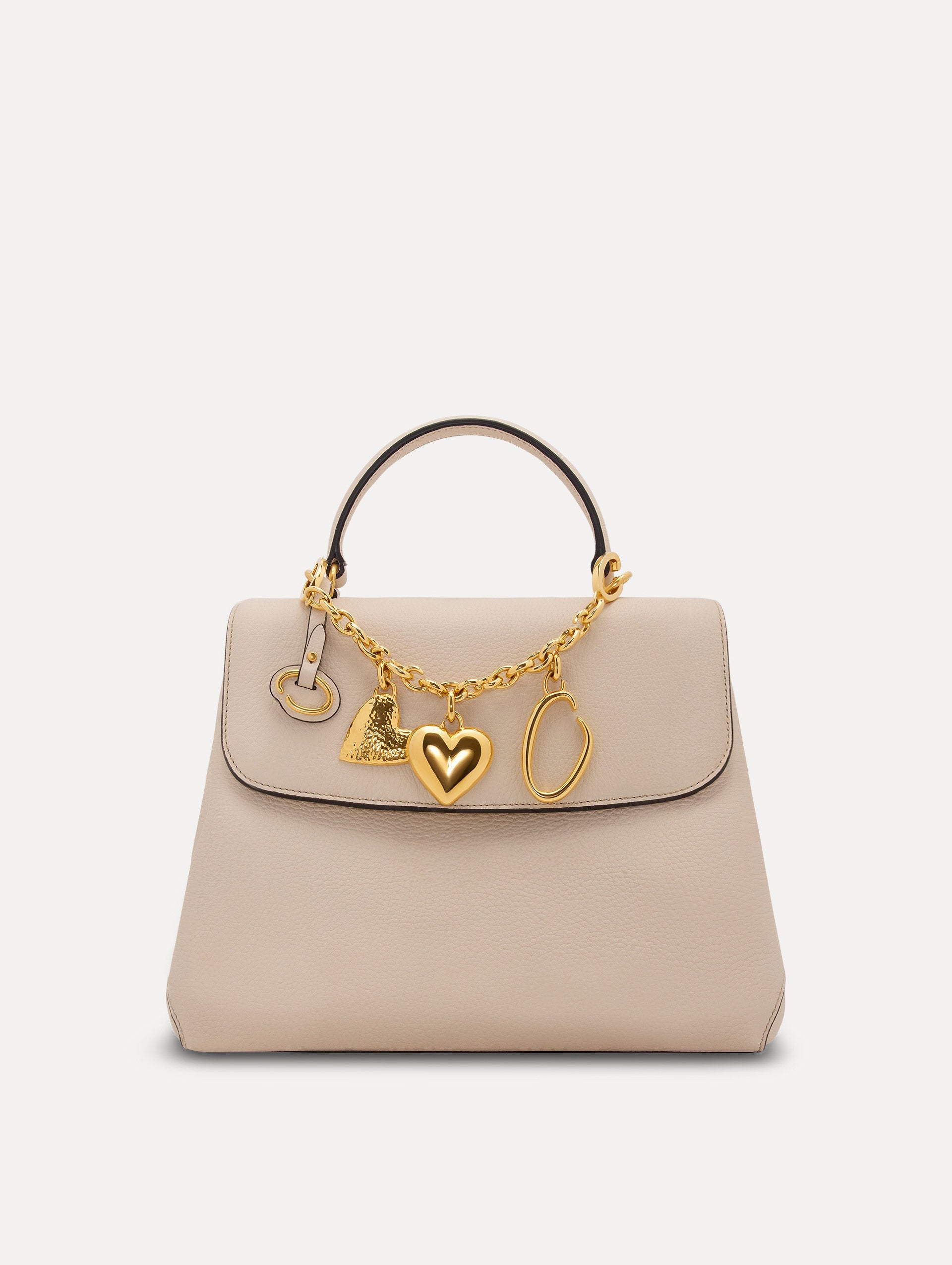 Heart & O Bag Charm in Gold styled with an ivory mini top handle handbag. Front View