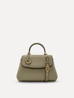 The Mini Poppy top handle bag in green. Front view.
