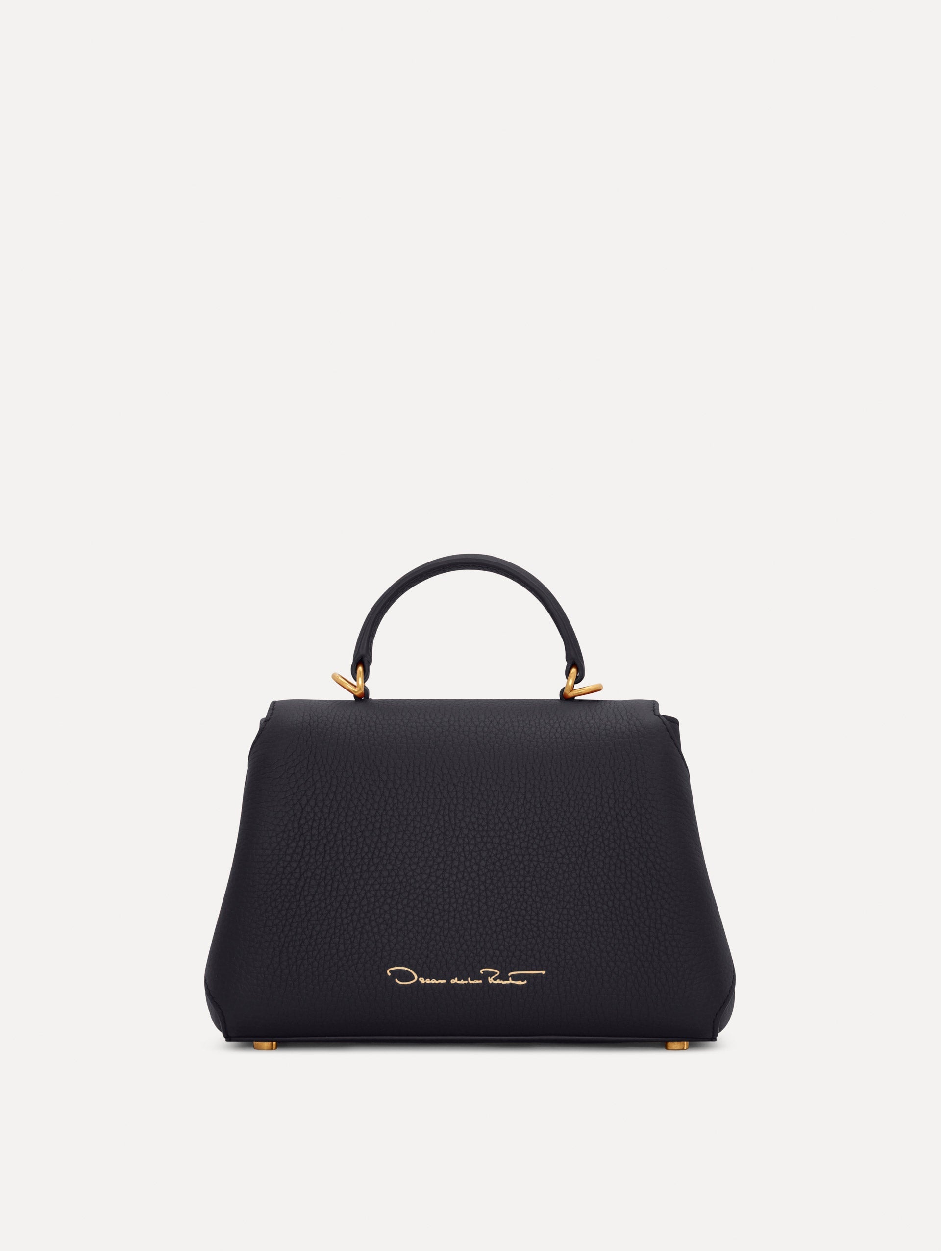 Mini Poppy in a light dark navy. The Mini Poppy is a top handle bag with a detachable shoulder strap, and it has the Oscar O logo attached around the top handle. Back View.