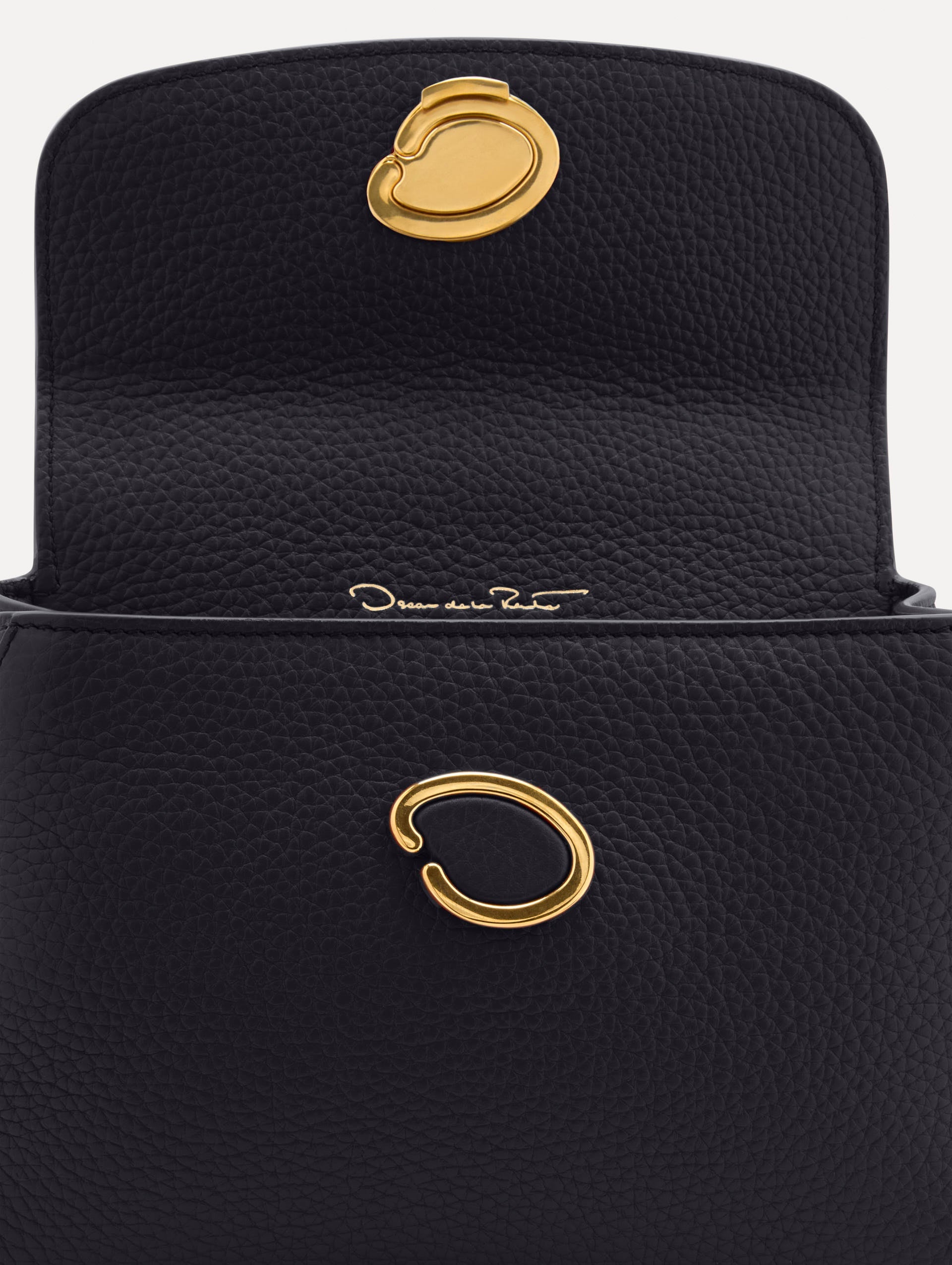Mini Poppy in a light dark navy. The Mini Poppy is a top handle bag with a detachable shoulder strap, and it has the Oscar O logo attached around the top handle. Zoom View.