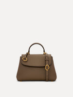 The Mini Poppy Leather Handbag in Stone with O tag around the Top handle and Detachable Shoulder Strap Front View