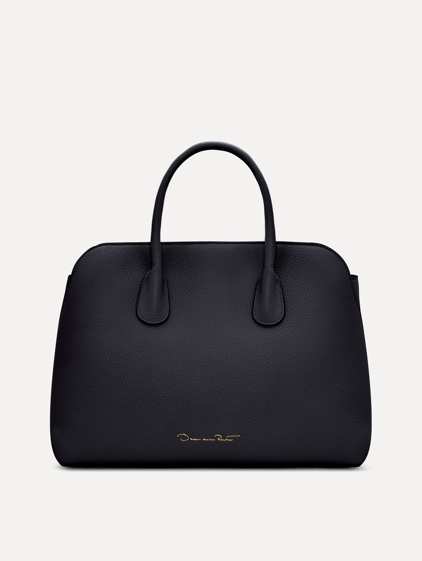 The Ivy top handle handbag in black, paired with some khaki pants. The bag comes with the Oscar O logo as a tag around the handle. Back View.