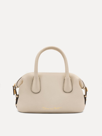 The Mini Dahlia leather handbag in ivory, with O logo tag around the top handle and a Gold Heart bag charm on the other side. Back View