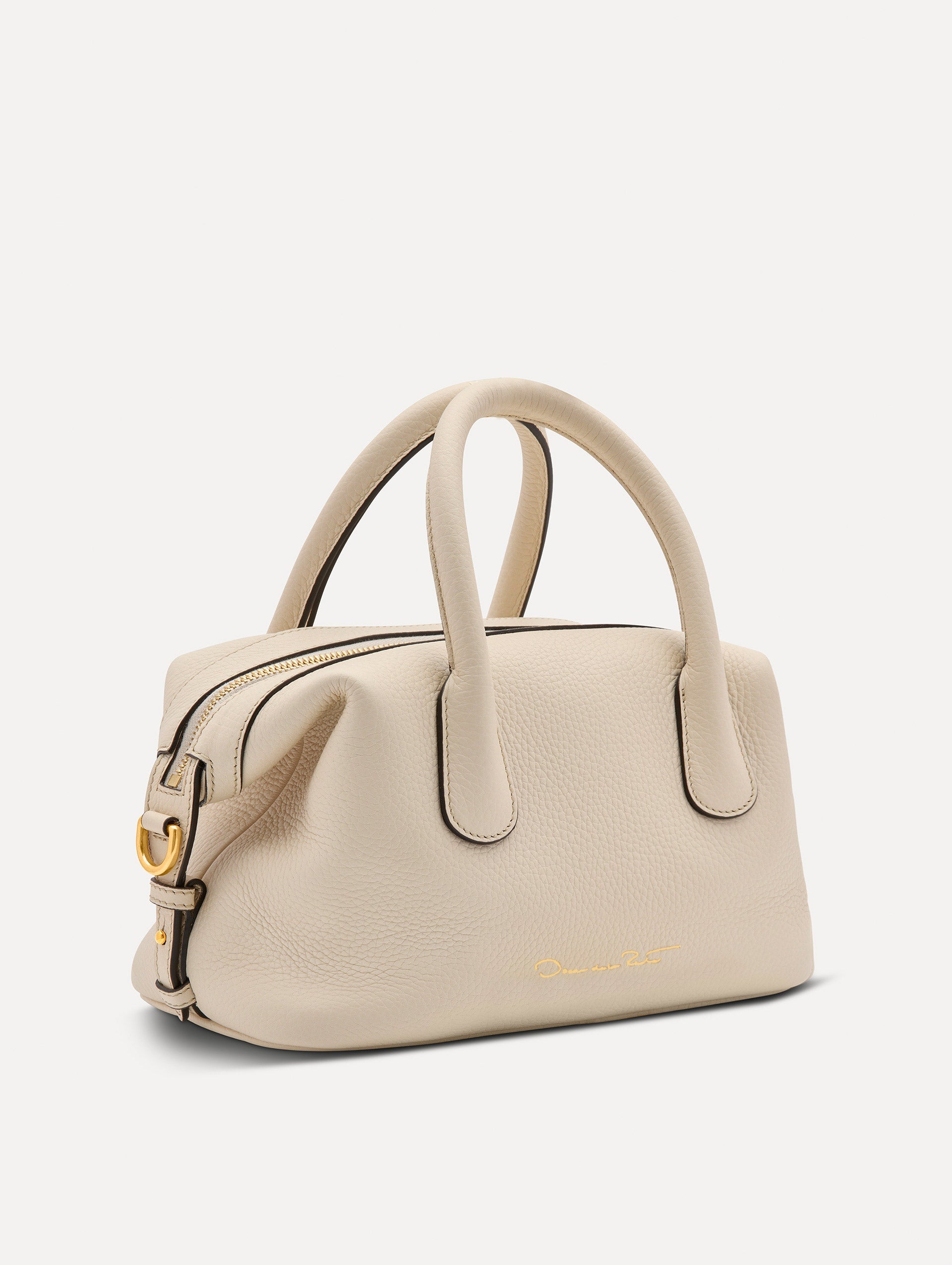 The Mini Dahlia leather handbag in ivory, with O logo tag around the top handle and a Gold Heart bag charm on the other side. Side View