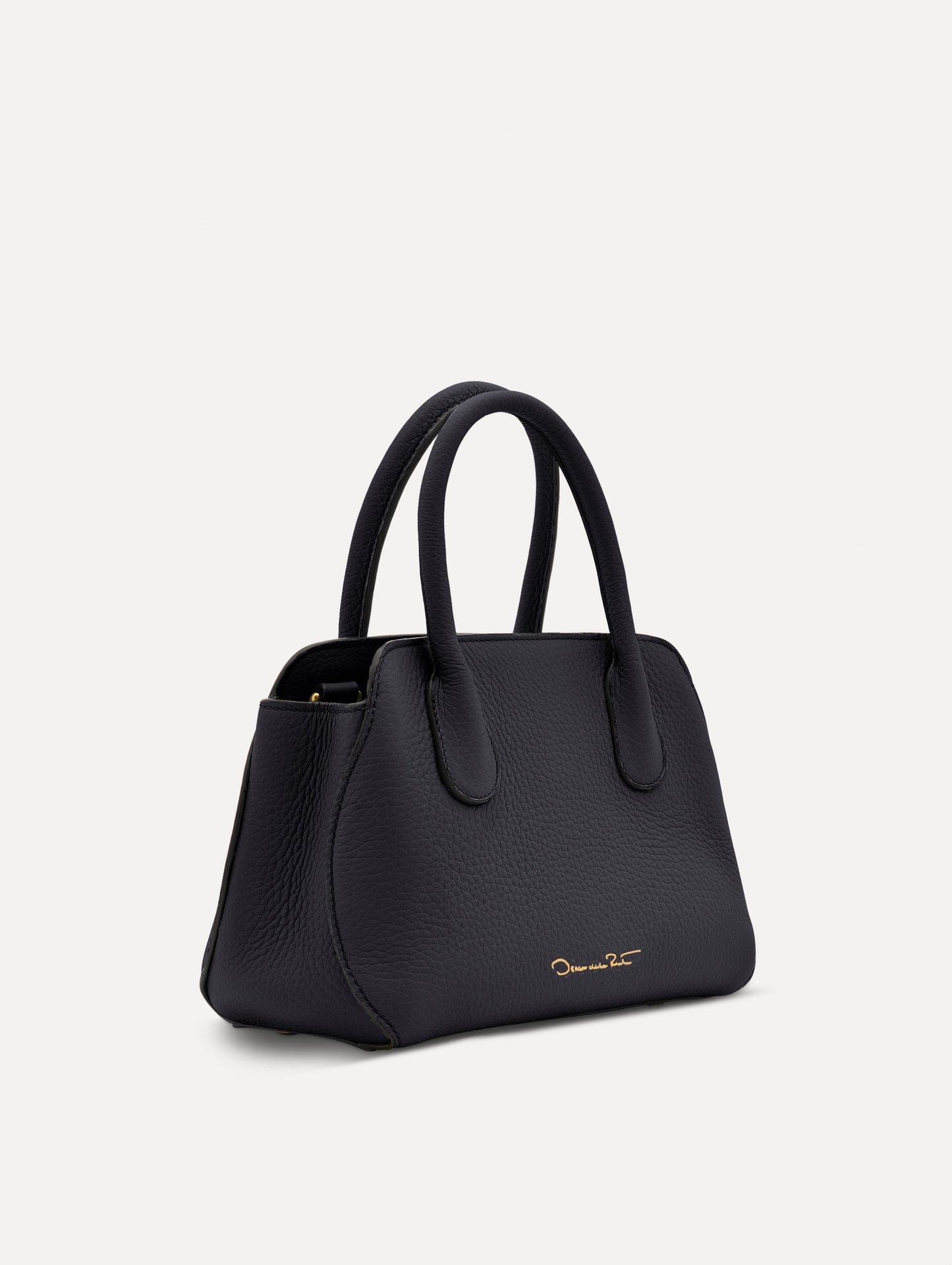 Mini Ivy in a light dark navy. The Mini Ivy is a top handle bag with a detachable shoulder strap, and it has the Oscar O logo attached around the top handle. Side View.