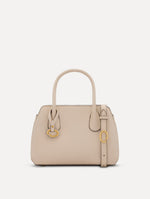 The Mini Ivy top handle handbag in Ivory. This bag comes with a detachable shoulder strap and has an Oscar O logo tag around the handle. Front View.