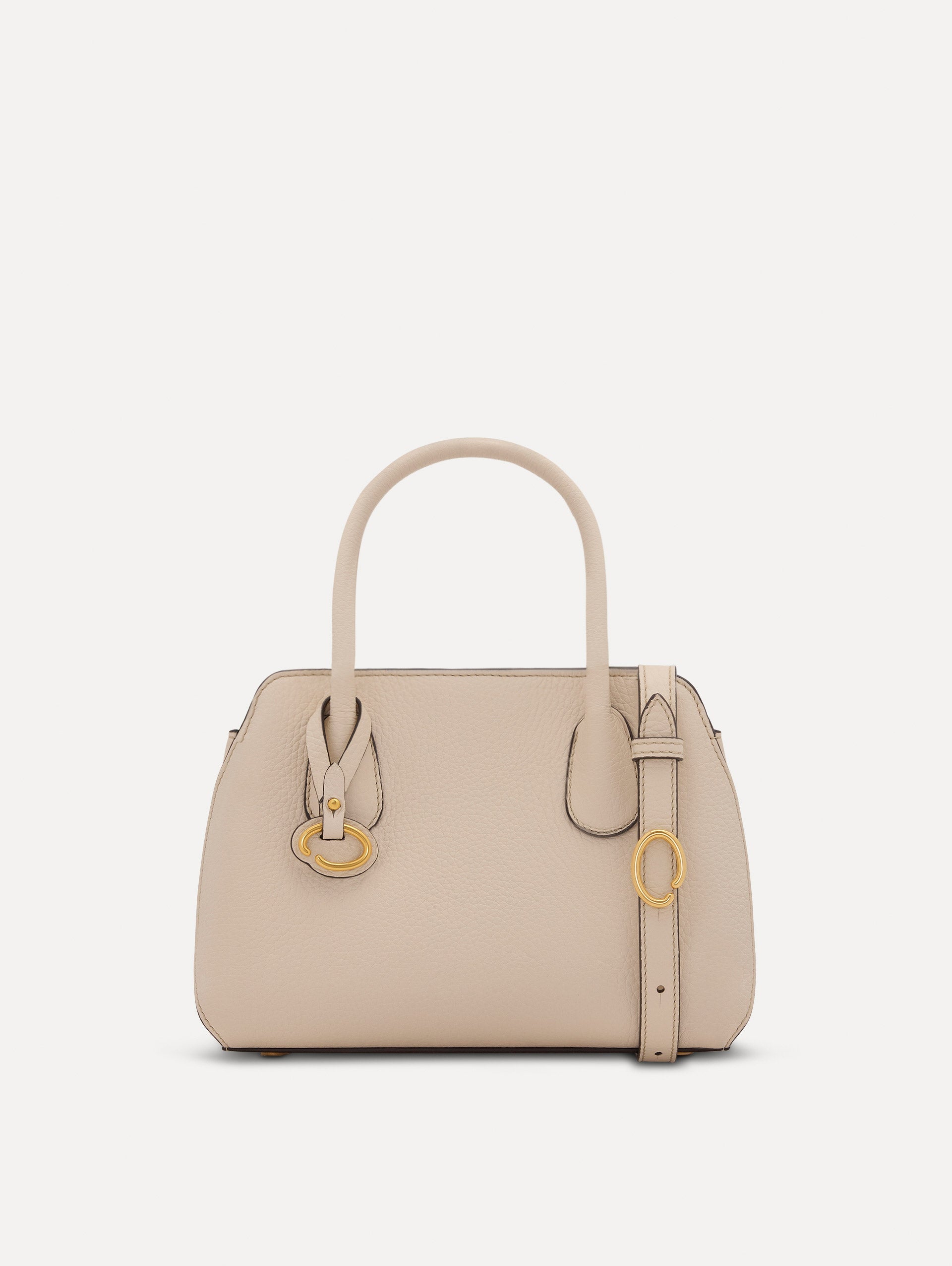 The Mini Ivy top handle handbag in Ivory. This bag comes with a detachable shoulder strap and has an Oscar O logo tag around the handle. Front View.