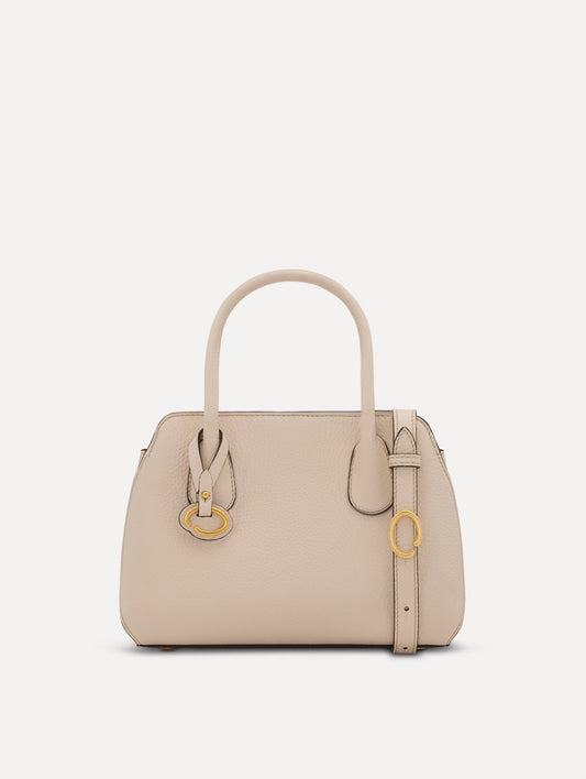 The Mini Ivy top handle handbag in Ivory. This bag comes with a detachable shoulder strap and has an Oscar O logo tag around the handle. Front View.