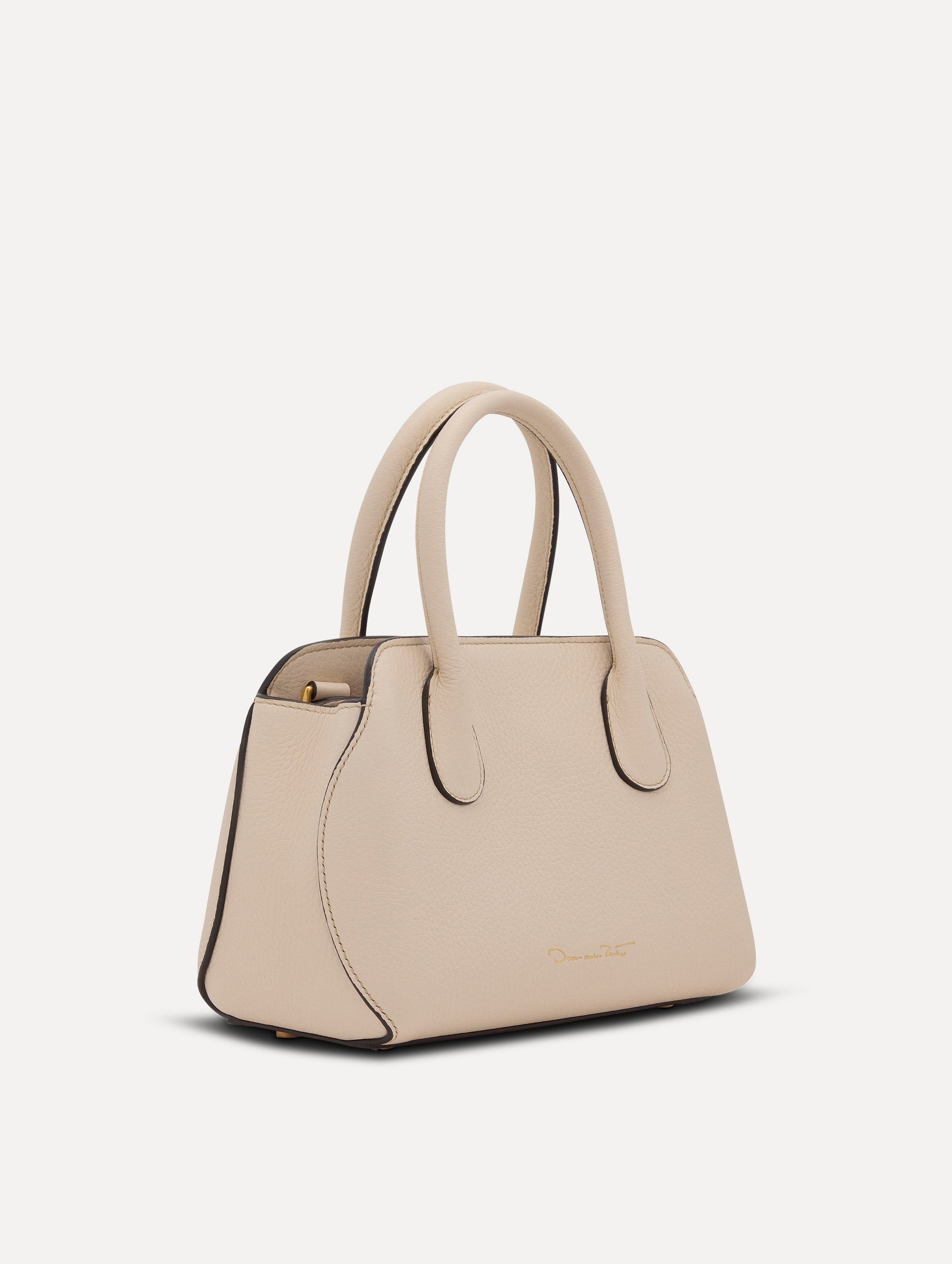 The Mini Ivy top handle handbag in Ivory. This bag comes with a detachable shoulder strap and has an Oscar O logo tag around the handle. Side View.