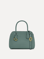 Mini Ivy in a light mint color. The Mini Ivy is a top handle bag with a detachable shoulder strap, and it has the Oscar O logo attached around the top handle. Front View.