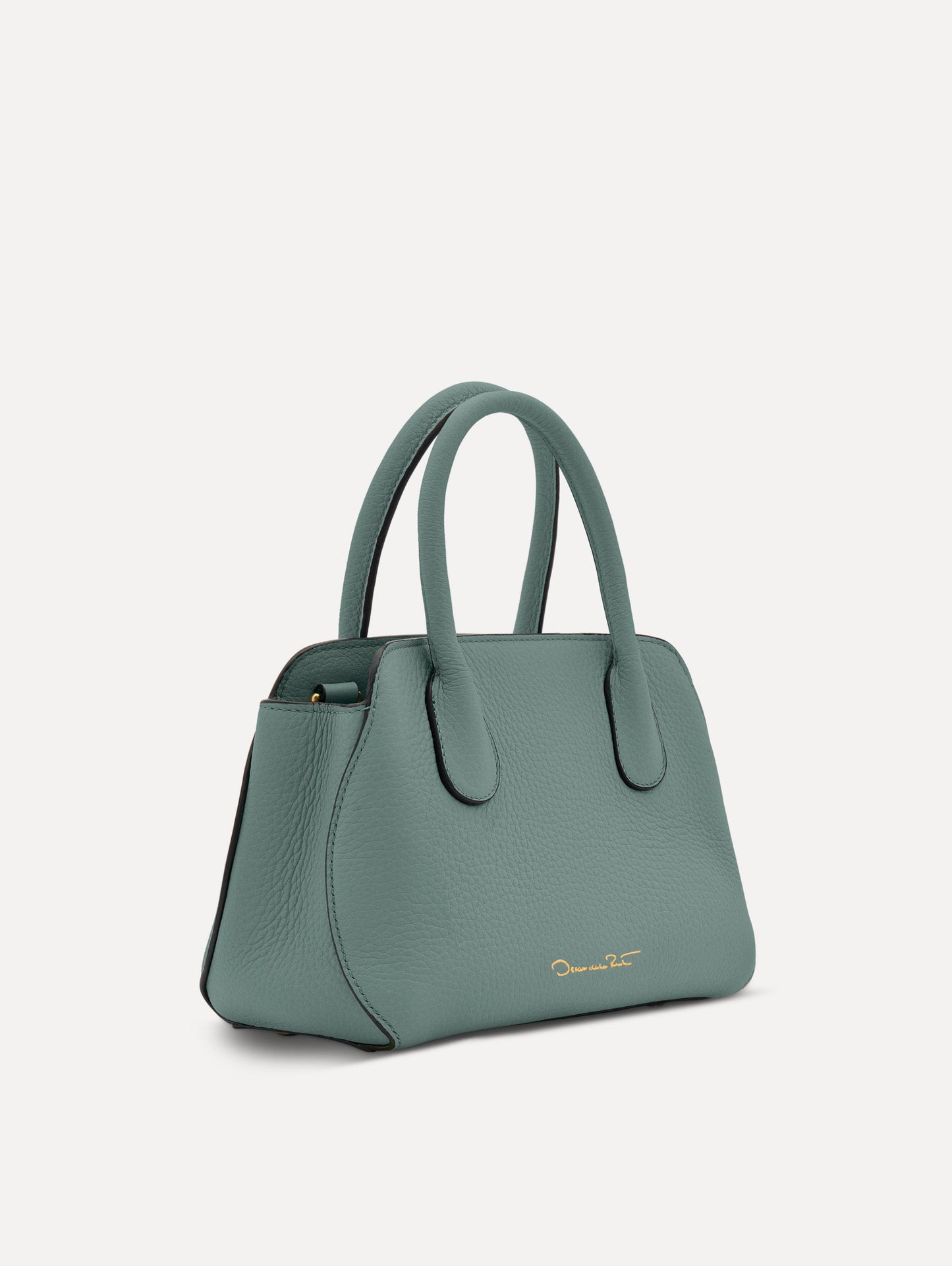 Mini Ivy in a light mint color. The Mini Ivy is a top handle bag with a detachable shoulder strap, and it has the Oscar O logo attached around the top handle. Side View.