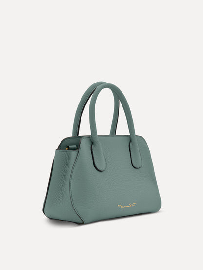 Mini Ivy in a light mint color. The Mini Ivy is a top handle bag with a detachable shoulder strap, and it has the Oscar O logo attached around the top handle. Side View.