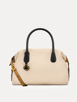 The Dahlia Handbag in Ivory with Black Top Handle and Honey sides. Adorned with Oscar de la Renta's signature logo in the bottom center of the back of the bag. Front View.