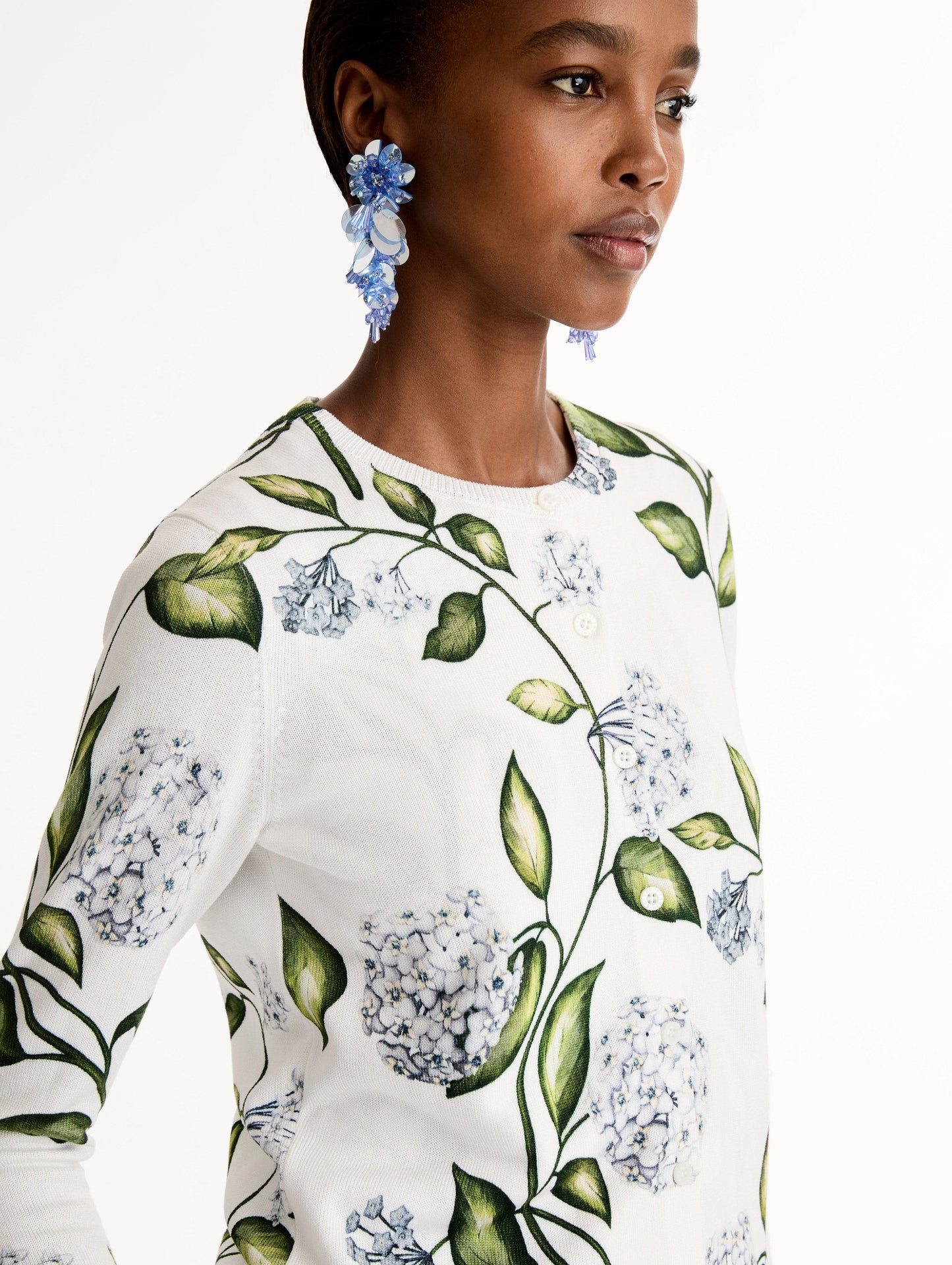 Classic ribbed-knit long sleeve cardigan with Porcelain motif.Crew neckline and banded trim. Close Up Side View.