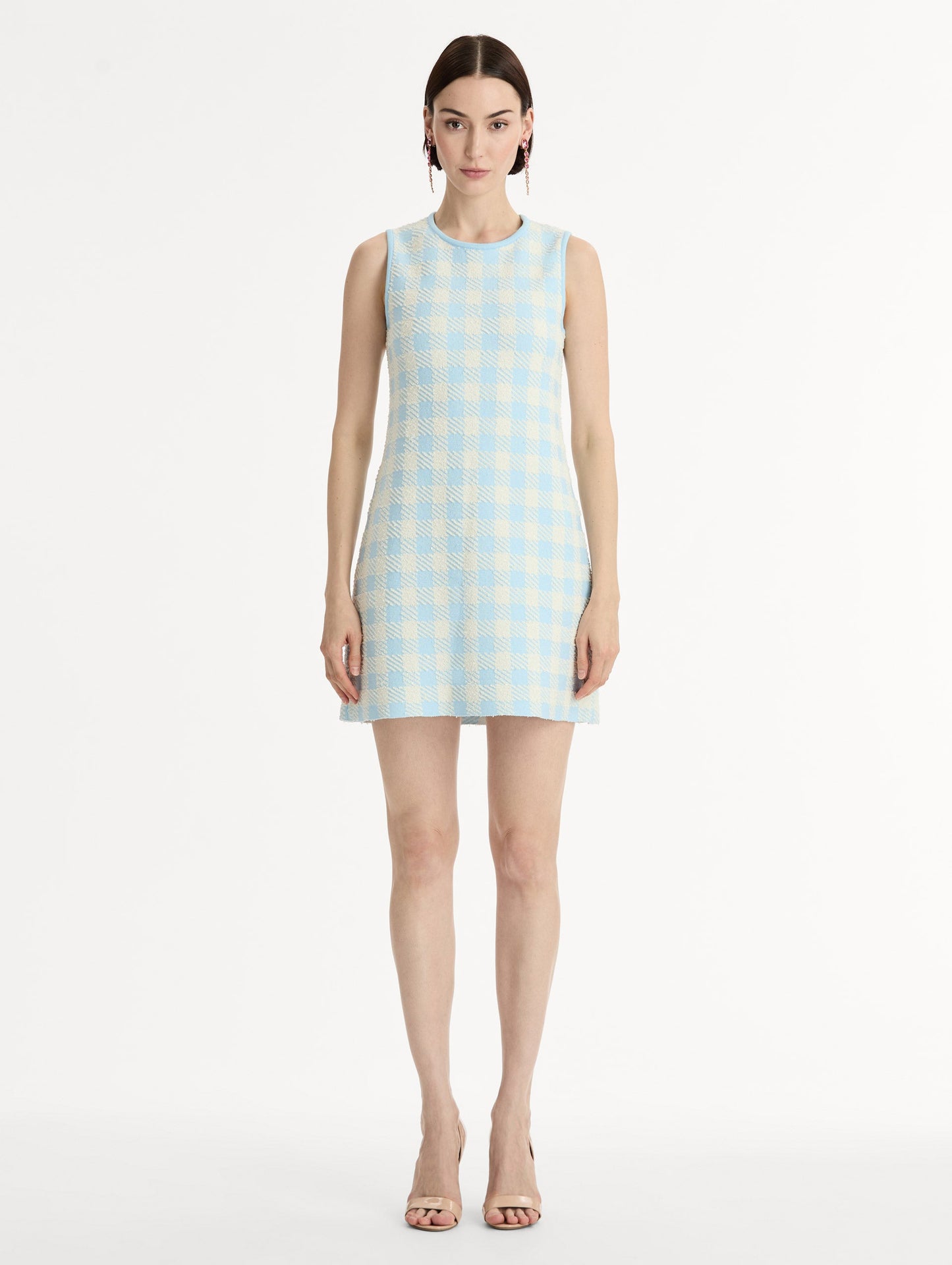 Sleeveless, texture jacquard, halter neck mini dress in Classic gingham pattern in pale blue and ivory. Front View.