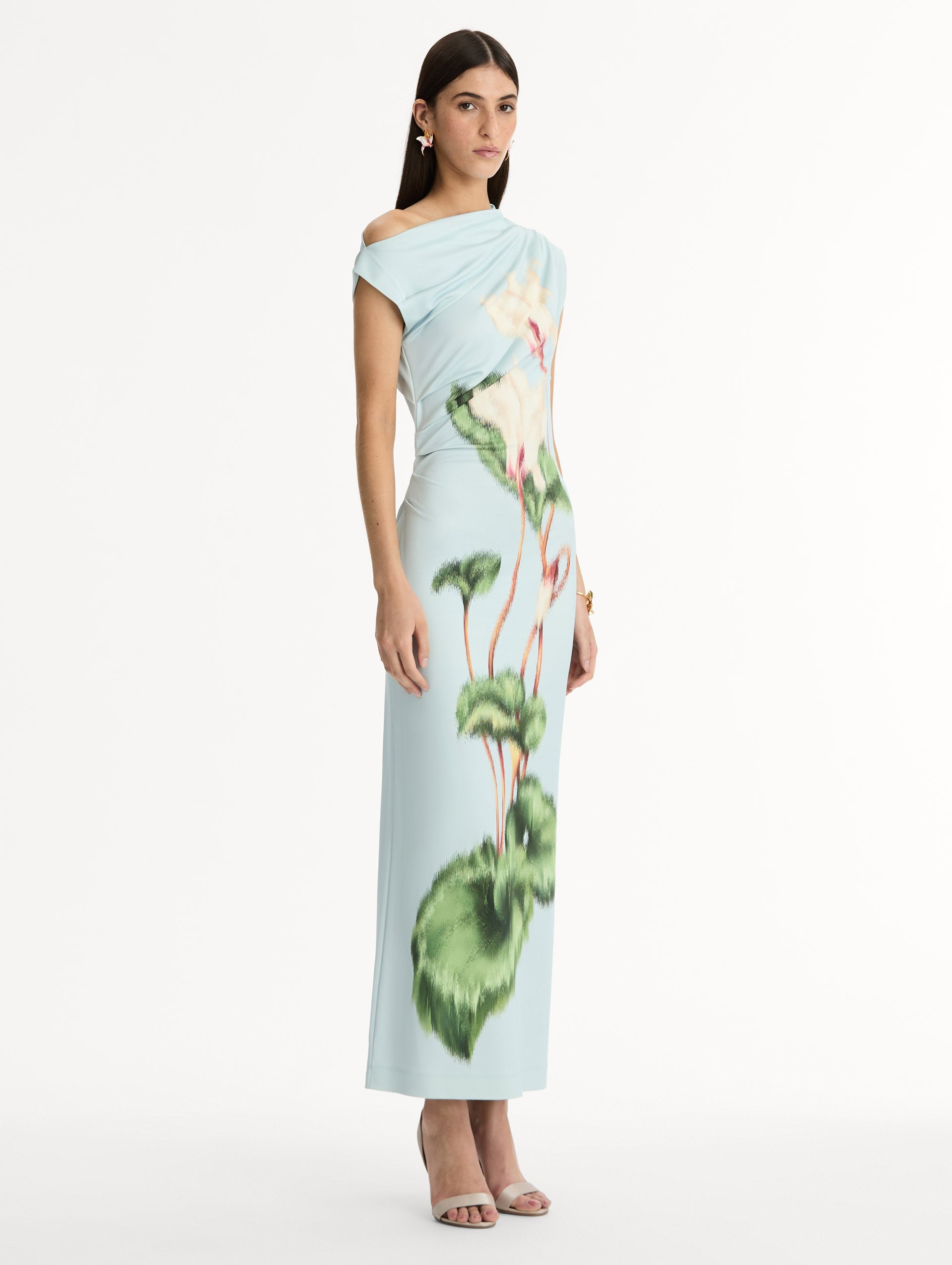Light blue, ankle length jersey dress. Chiné Cyclamen motif with blurred edges. Asymmetric neckline, off the shoulder. Side view.