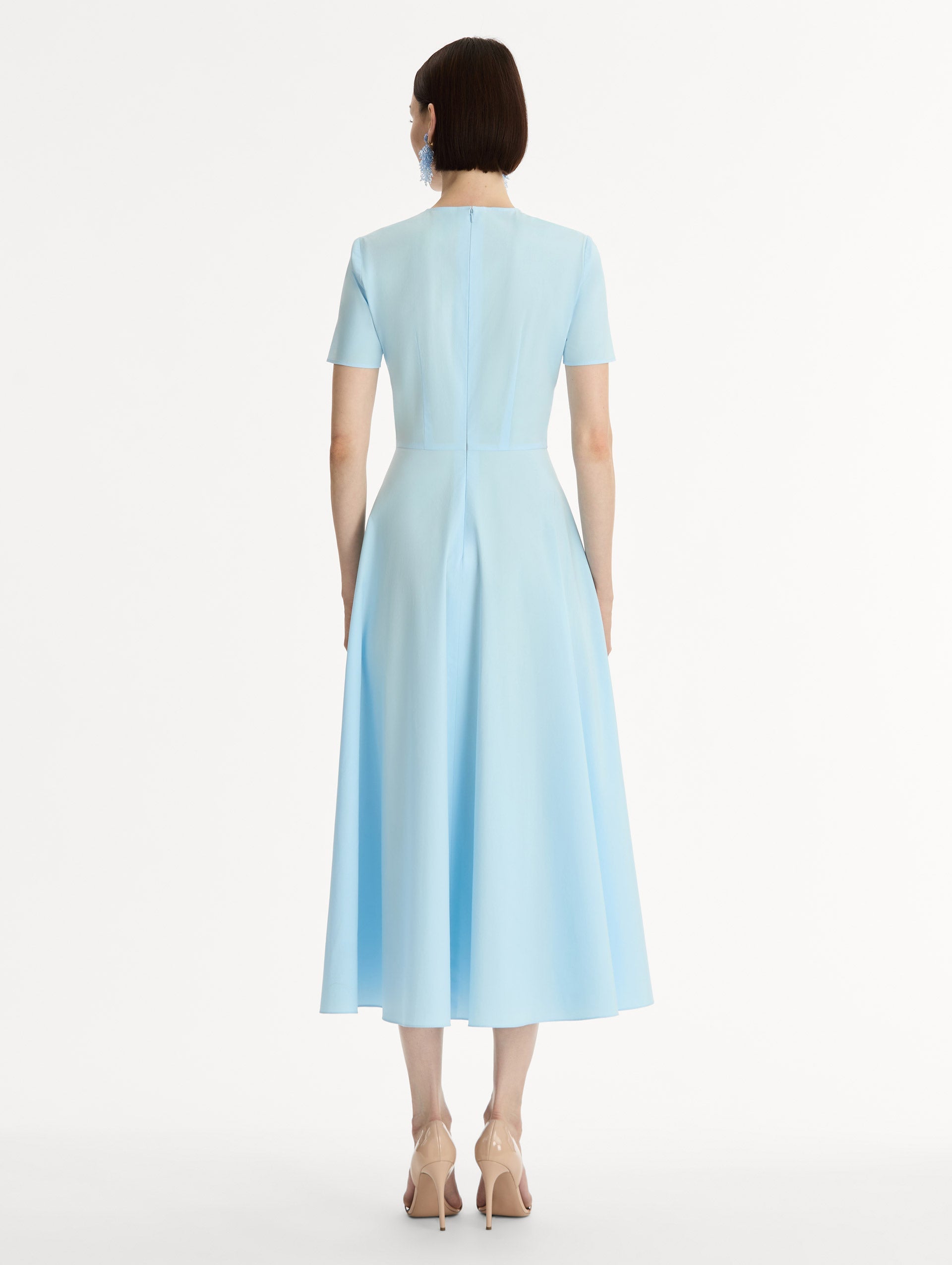 Short sleeve, light blue cotton poplin midi dress. Fitted bodice, full A-line skirt. Chiné Cyclamen motif with blurred, edges. Back View.