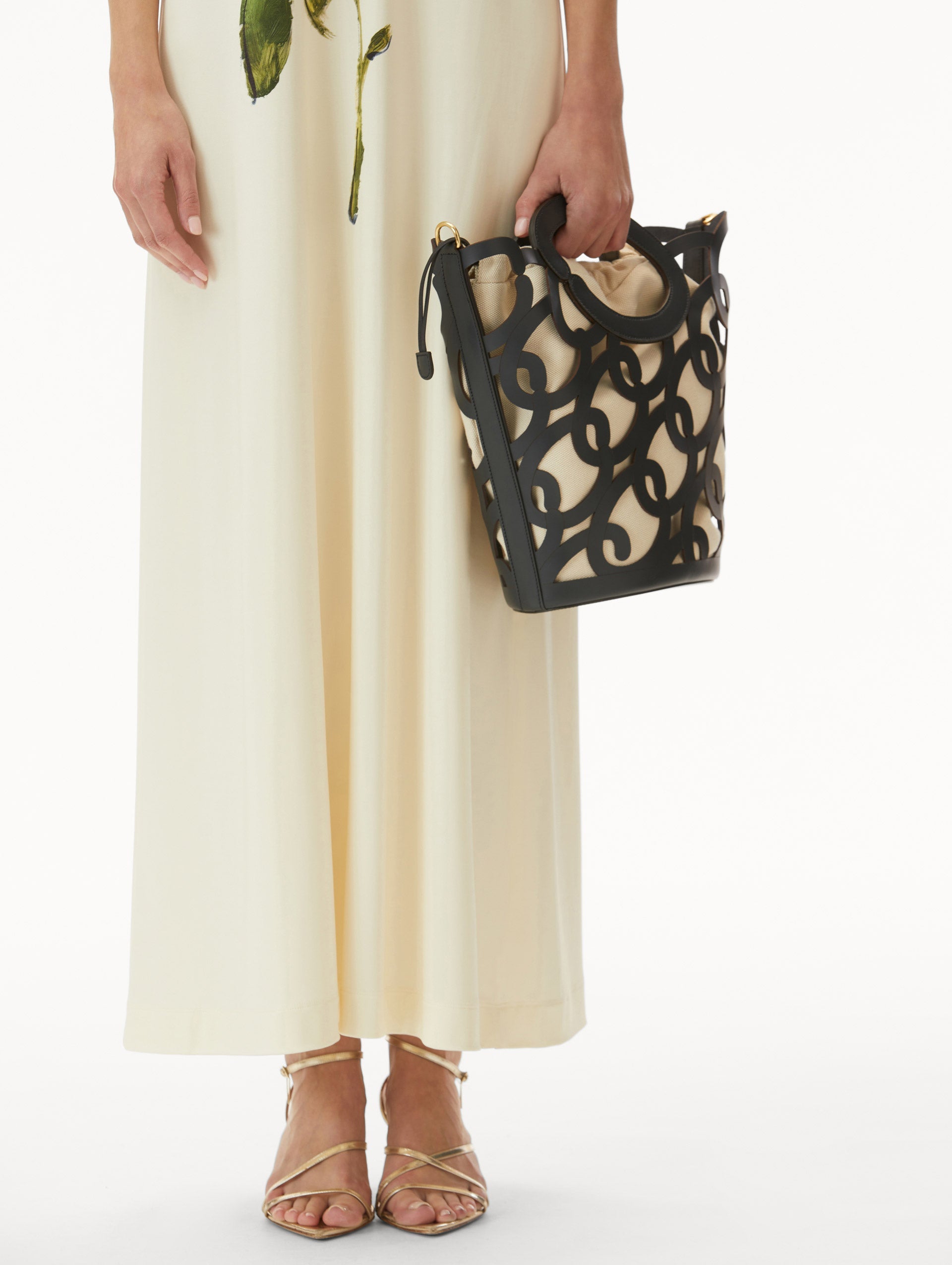 Model in white dress wearing Navy Oscar Chain-Link Leather Tote, formed by interlocking 'O' emblems and a large 'O' forms the top handle, with a removable interior pouch. Front View