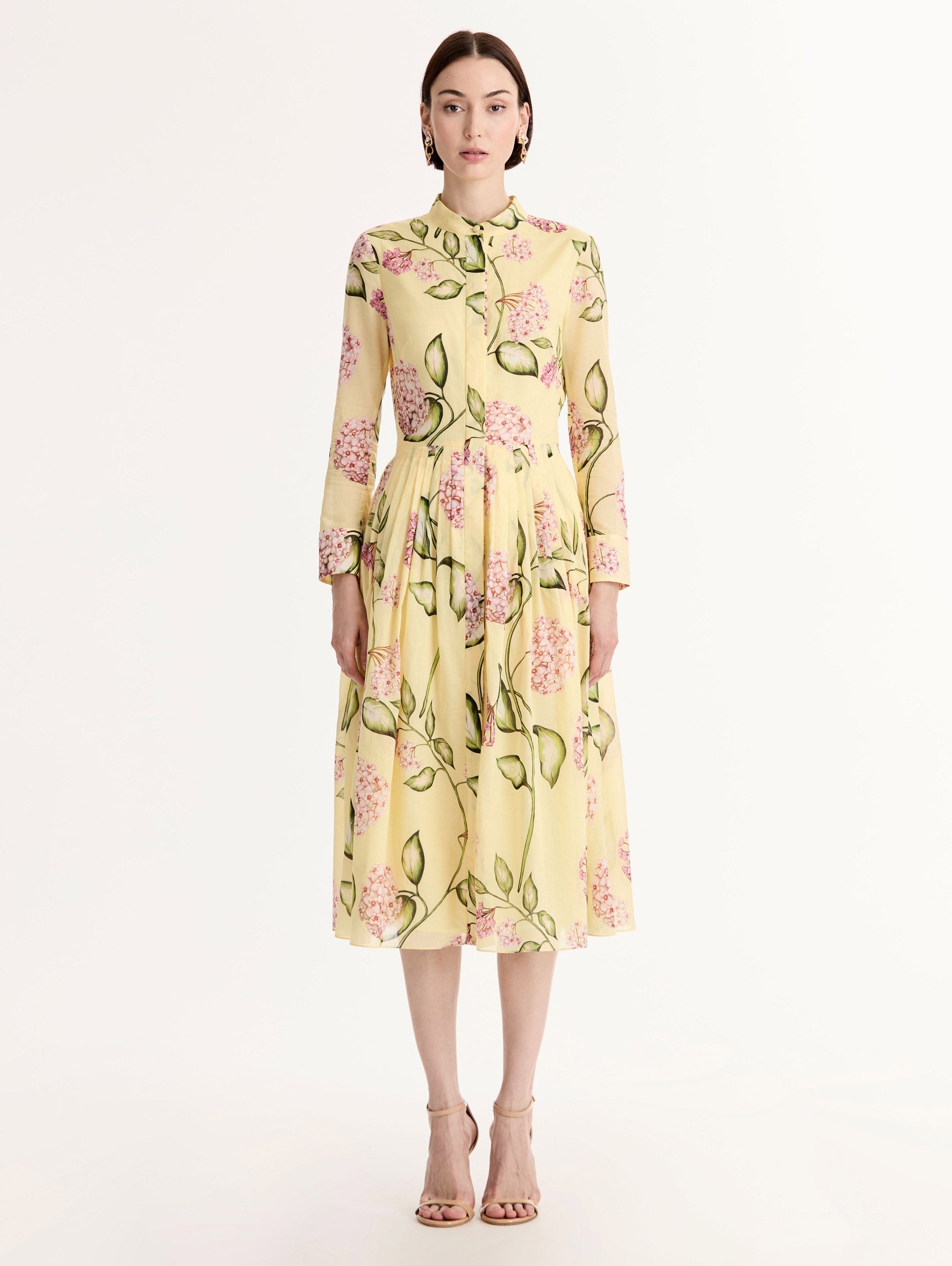 Long-sleeve, yellow cotton poplin midi dress. Porcelain flower print. Pleated silhouette. Concealed button front. Softly structured collar. Front View.