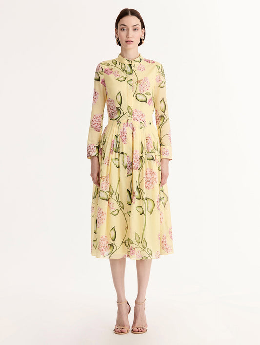 Long-sleeve, yellow cotton poplin midi dress. Porcelain flower print. Pleated silhouette. Concealed button front. Softly structured collar. Front View.