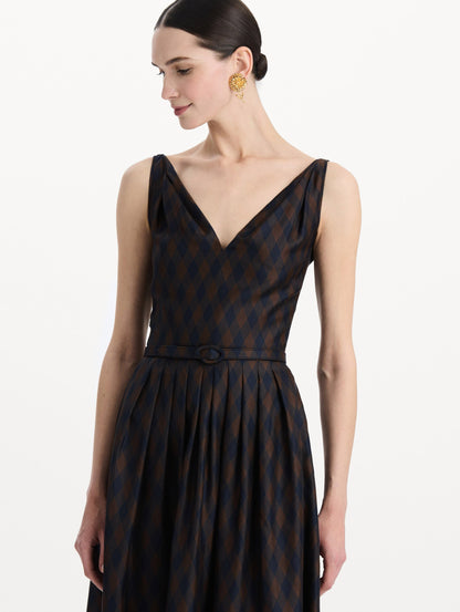 The model is wearing the argyle silk twill dress with a sleeveless silhouette, a V-neckline, and an argyle print in navy and brown. Zoom view.