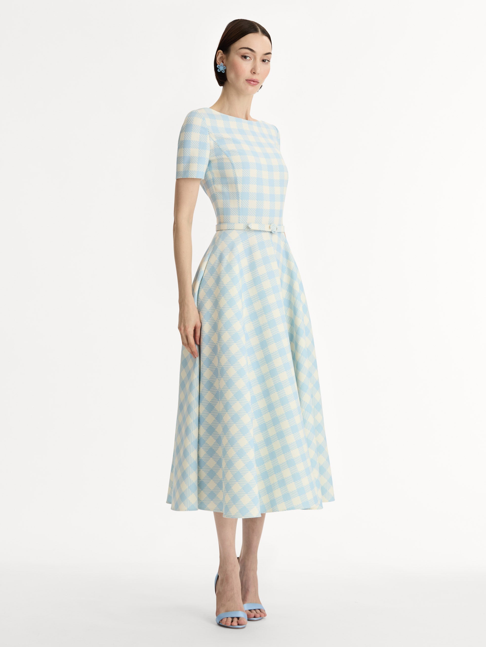Pale blue and ivory gingham wool-blend midi dress. Fitted bodice, short sleeves, ull skirt, finished with a covered belt at the waist. Pocketed. Side View.