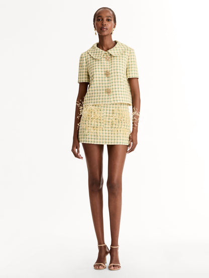 Short Sleeve Cropped Checked Tweed Jacket, Floral Button Closure, Butter Yellow with Green Checks, Rounded Collar. Front View.