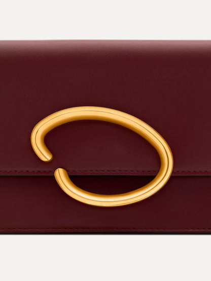 Maroon O Pochette with gold hardware and abstract O Clasp. Zoom View.
