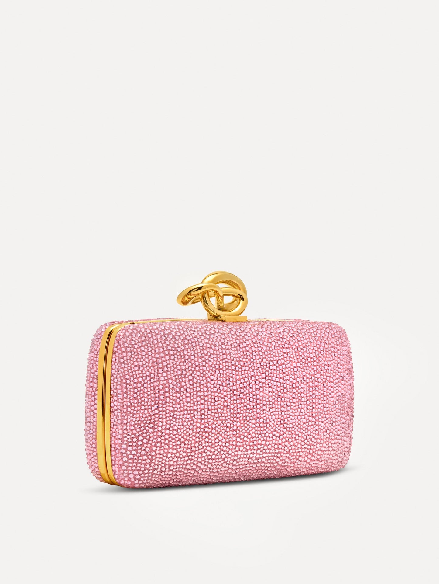 Pink Crystal Pavé Knot Minaudière featuring a rectangular silhouette, allover pavé embellishment, and sculptural gold knot clasp.