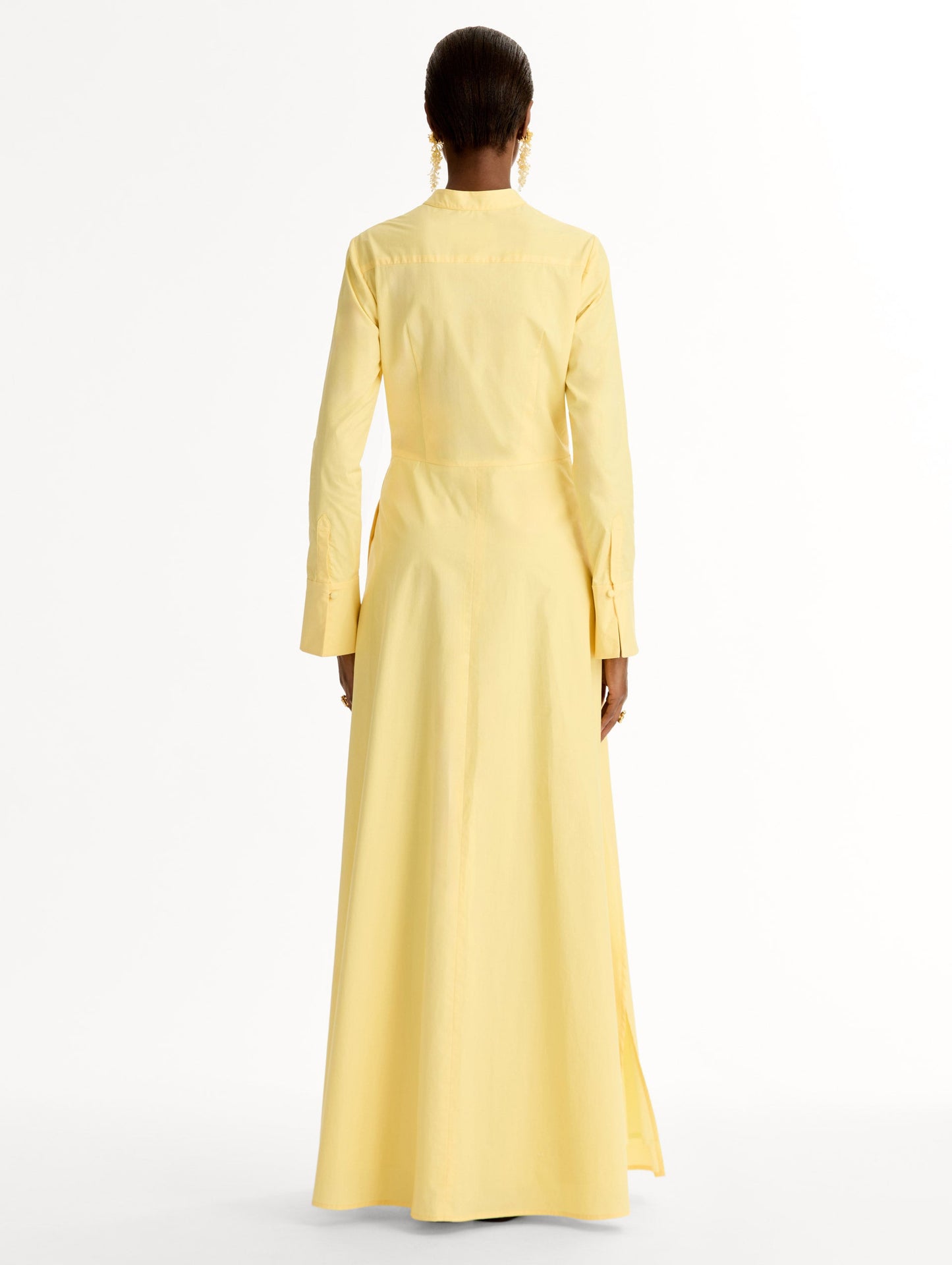 Yellow cotton poplin caftan with a mandarin collar and concealed button front. Chiné Cyclamen motif softly blurred, edges. Full-length sleeves. Back View.