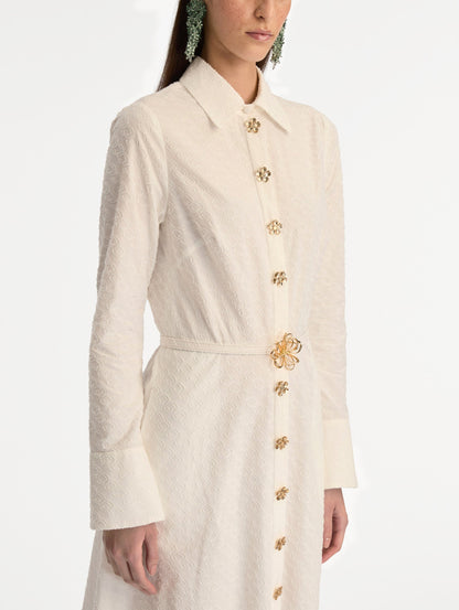 Ivory Oscar Chain-Link Cotton Poplin Caftan featuring a collared neckline, flared sleeves, gold button front, and belted waist with floral buckle. Zoom View.